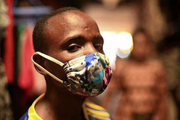 Eugene Amuri, a vendor at the Kimironko market wears a handmade "kitenge" cloth mask as he attempts to protect against the coronavirus disease (COVID-19), in Kigali, Rwanda March 17, 2020. (REUTERS/Maggie Andresen)