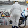 Medical workers transfer a passenger with COVID-19 from the Greg Mortimer cruise liner to an ambulance at Montevideo's port on April 8, 2020