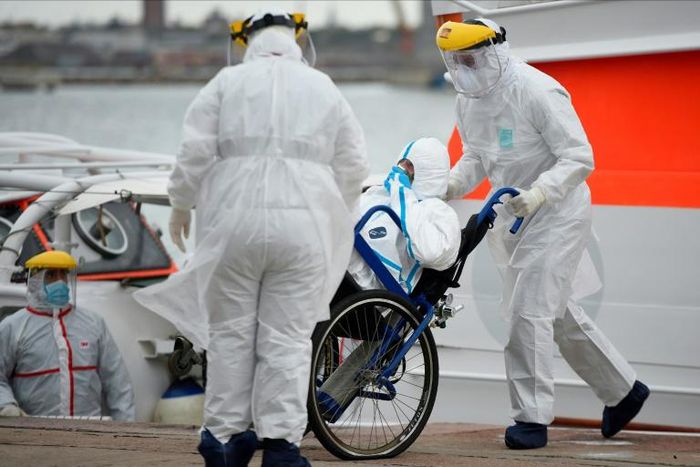 Medical workers transfer a passenger with COVID-19 from the Greg Mortimer cruise liner to an ambulance at Montevideo's port on April 8, 2020