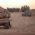 Israeli infantry soldiers gather next to tanks and an armoured personnel carrier near the Israeli border with the Gaza Strip on Sunday