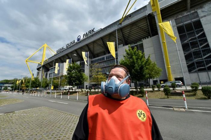 A Borussia Dortmund worker wears a mask outside the Signal Iduna Park stadium before the team face Schalke 04 as the Bundesliga resumes