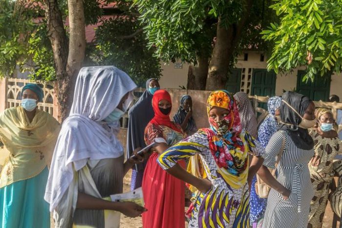 Voters stand apart outside a polling station in Cotonou