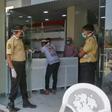 Mask-clad security guards and a patient at the entrance to al-Kubi hospital in Yemen's southern coastal city of Aden