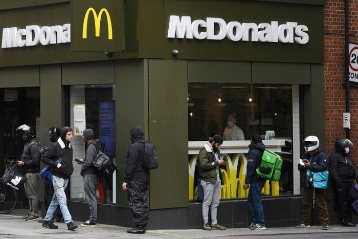 Delivery riders queue  outside a McDonald's in London; the company is facing a sexual harassment complaint filed at the OECD by an international coalition of labor unions