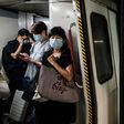 Commuters wear face masks on a metro train in Hong Kong. The city's leader says coronavirus is running "out of control" afater a daily record number of new cases