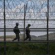 South Korean soldiers patrolling along a barbed wire fence at the  Demilitarized Zone with North Korea