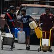 A man carries water in Caracas May 19, 2020 amid the coronavirus pandemic