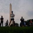 Members of  the Covid Memorial Project hold American flags in front of the Washington monument to commemorate the victims of the coronavirus