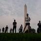 Members of  the Covid Memorial Project hold American flags in front of the Washington monument to commemorate the victims of the coronavirus