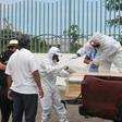 Workers wrap with plastic a coffin with the remains of a person who died from the coronavirus, COVID-19 in Guayaquil, Ecuador