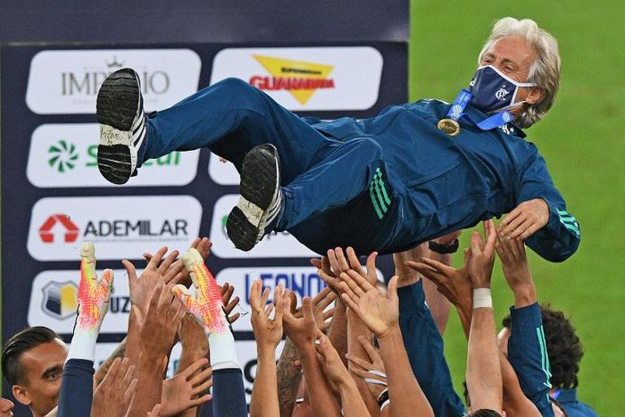 Flamengo players tossed 65-year-old coach Jorge Jesus into the air after clinching the Rio de Janeiro state title in an empty Maracana