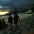 People wear face masks as they walk along Ipanema Beach in Rio de Janeiro on May 19, 2020. The peak of Brazil's outbreak is not expected until June