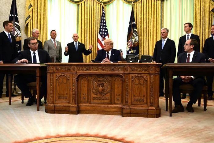 US President Donald Trump (C), Kosovar Prime Minister Avdullah Hoti (R) and Serbian President Aleksandar Vucic (L) listen to US Vice President Mike Pence during a signing ceremony, in the Oval Office of the White House in Washington, DC, on September 4...