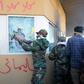 Members of Iraq's Hashed al-Shaabi, a mostly Shiite network of armed groups trained and armed by powerful neighbour Iran, smash a window at the US embassy in Baghdad in December 2019