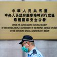 Police walk past a plaque outside the Office for Safeguarding National Security of the Central People's Government in the Hong Kong Special Administrative Region after its official inauguration