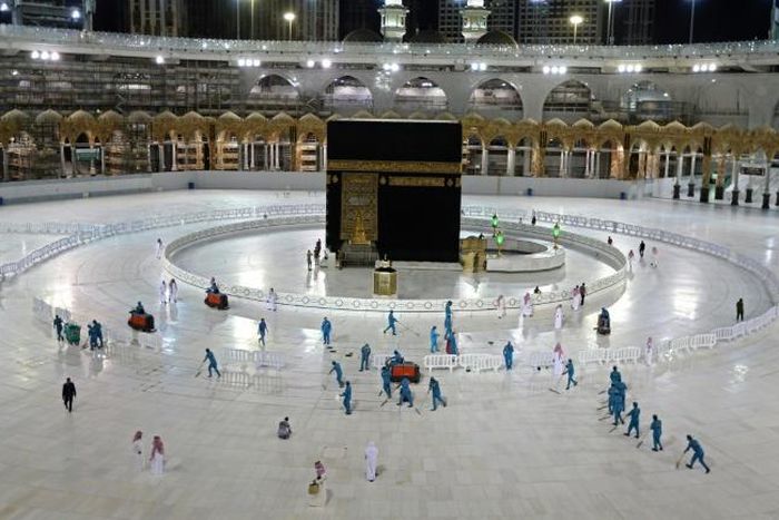 In this file photo taken on April 24, 2020, sanitation workers disinfect the area around the Kaaba in Mecca's Grand Mosque. On Monday Saudi Arabia said it will hold a 'limited' hajj this year due to the coronavirus pandemic