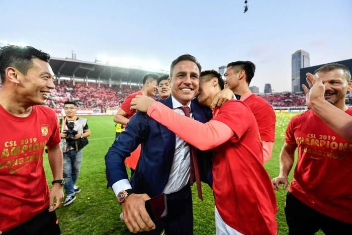 Guangzhou Evergrande's head coach Fabio Cannavaro celebrates with his players and after winning the Chinese Super League last season. They will now be able to begin their delayed title defence from July 25