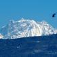 A helicopter carrying a rescue team flies in front of the Annapurna mountain range, in Pokhara, west of Kathmandu, during the initial search in January