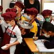 Students wearing face masks as a preventive measure to curb the spread of the COVID-19 coronavirus collect their lunch at an elementary school in Taipei in April 2020