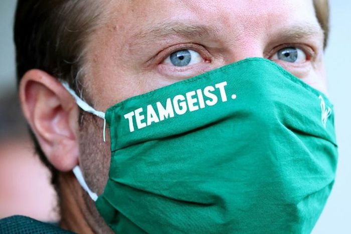 The Werder Bremen squad, under head coach Florian Kohfeldt seen here wearing a face mask bearing the logo "team spirit", has also agreed to another pay-cut