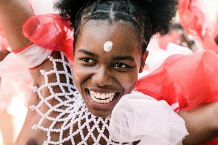 Adorned in colourful beads, a young woman is pictured in 2019 dancing before the Zulu king holding a long reed