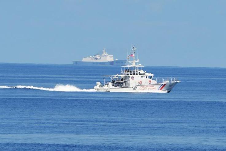 A Philippine coastguard ship BRP Langgam sails past a Chinese coastguard ship (background) near the Scarborough shoal in 2019