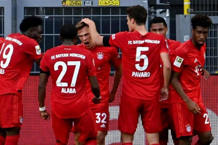 Bayern Munich midfielder Joshua Kimmich (C) celebrates scoring the winning goal at Borussia Dortmund.
