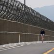 A cyclist rides along the barbed-wire fence of the Demilitarized Zone (DMZ) separating North and South Korea, on the South Korean island of Gyodong on June 18, 2020