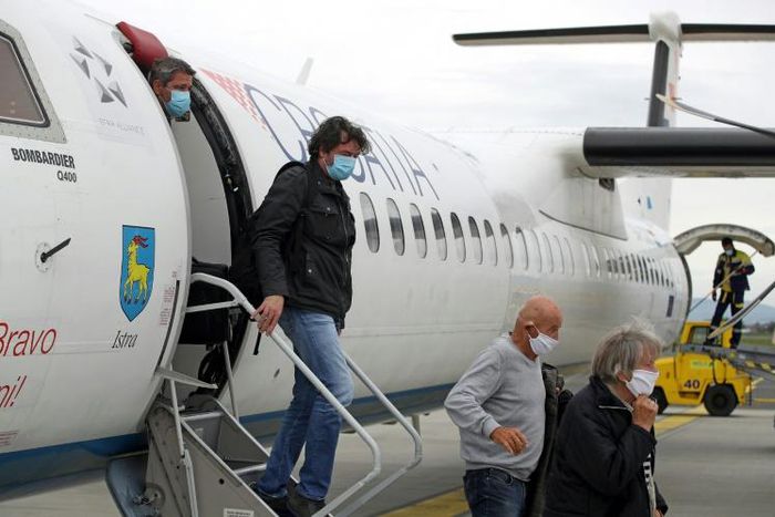 Passengers wearing masks get off a plane at Zagreb International Airport Croatia, on May 11, 2020