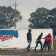 Young men haul a burning tyre during protests at Tygerberg Raceway near Cape Town. The motor-racing venue was invaded on August 6 by people demanding land
