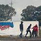 Young men haul a burning tyre during protests at Tygerberg Raceway near Cape Town. The motor-racing venue was invaded on August 6 by people demanding land