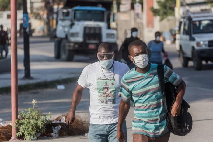 Two men wear masks as they walk in the streets of downtown Port-au-Prince on March 26, 2020. When the novel coronavirus first appeared  in Haiti authorities and humanitarian experts panicked, worried about the country's decrepit health system -- but he...