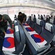 Flag-wrapped coffins containing the remains of nearly 150 South Koreans killed in the Korean War were flown back to Seoul