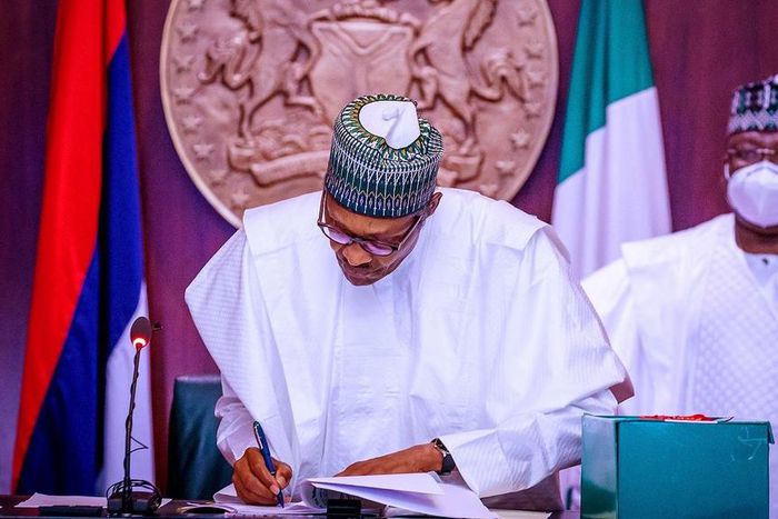 President Muhammadu Buhari signs into law the revised N10.8trn 2020 Budget as President of the Senate, Ahmad Lawan watches on. [Twitter/@Buharisallau1]