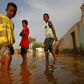 Sudanese boys make their way through a flooded street in the capital's twin city of Omdurman
