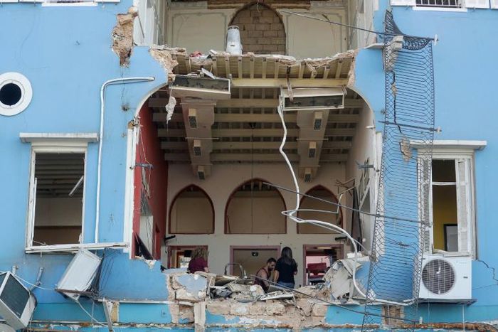 A Lebanese couple inspect the damage to their home in the capital's Gemmayzeh neighbourhood which overlooks the destroyed port of Beirut