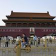 People cycle past Tiananmen gate on the eve of the 31st anniversary of the June 4, 1989 crackdown on pro-democracy protests in Beijing