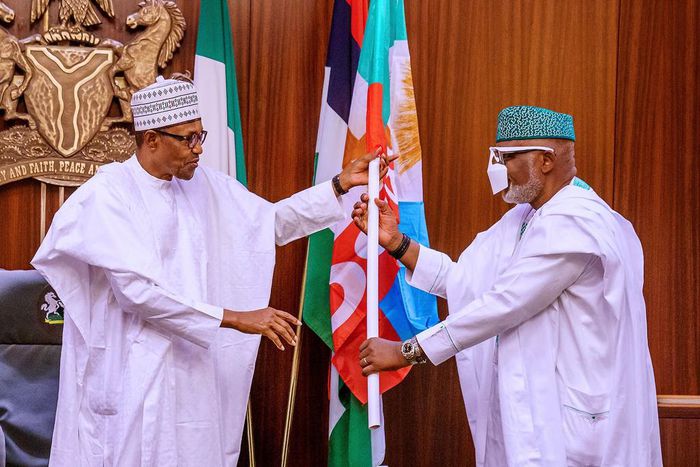 President Muhammadu Buhari presents All Progressives Congress (APC)'s flag to Ondo state Governor, Rotimi Akeredolu. [Twitter/@NigeriaGov]