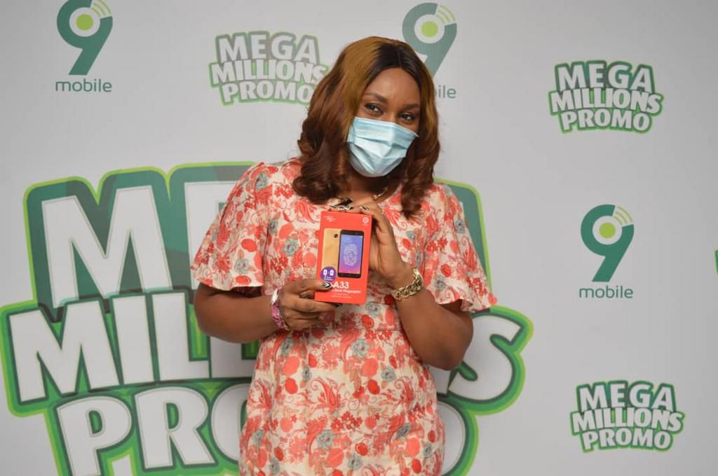 Egondu Njoku showing off her smartphone prize at the ongoing 9mobile Mega Millions Promo prize presentation in Port Harcourt