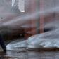 A demonstrator is hit by a jet from a water cannon during a protest in homage to the victims of Chile's 1973 military coup, in Santiago, September 2020