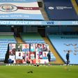 A screen displays images of fans in front of empty stands ahead of the Premier League match between Manchester City and Arsenal