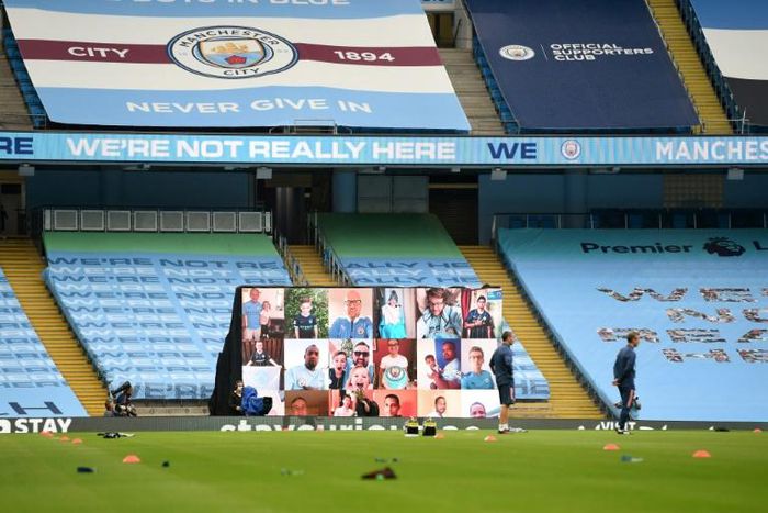 A screen displays images of fans in front of empty stands ahead of the Premier League match between Manchester City and Arsenal