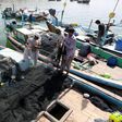 Iranian fishermen seen in this 2015 picture clean their nets after unloading their catch in the southern port of Chabahar