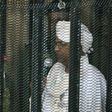 Sudan's deposed president Omar al-Bashir stands in a defendant's cage during the opening of his corruption trial in Khartoum last August