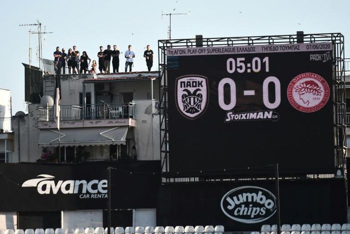 Roof dwellers: PAOK fans watch the Greek Super League game against Olympiakos above the Toumba stadium in Thessaloniki