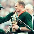 President Nelson Mandela (L) hands the Rugby World Cup trophy to South Africa captain Francois Pienaar after the 1995 final in Johannesburg