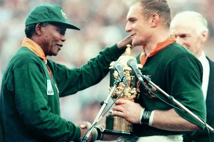 President Nelson Mandela (L) hands the Rugby World Cup trophy to South Africa captain Francois Pienaar after the 1995 final in Johannesburg