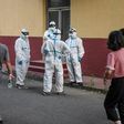Medical workers in protective equipment take a break at a testing centre for COVID-19 in Beijing this week after a new outbreak whch is also casting fresh doubts over the suspended Chinese Super League football season