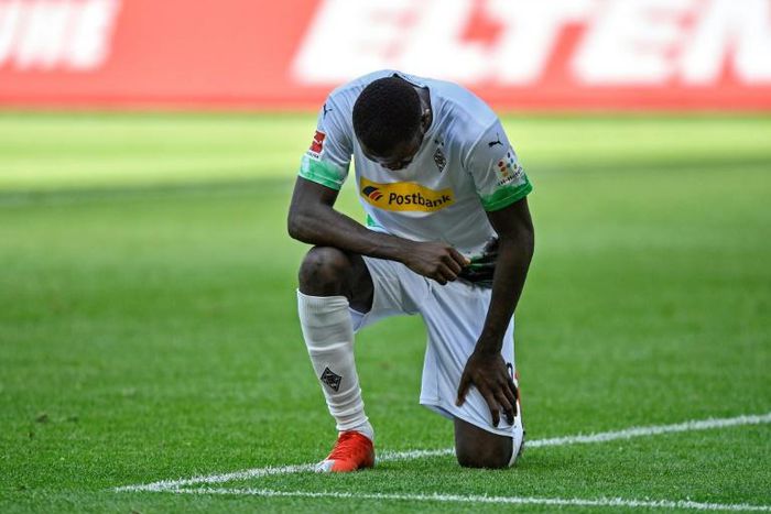 Moenchengladbach's French forward Marcus Thuram takes a knee