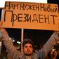 A man holds a poster reading "We need a new president" during a protest rally against police violence